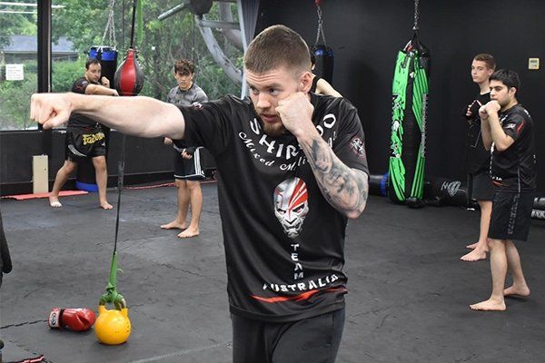 A group of young men are practicing martial arts in a gym.