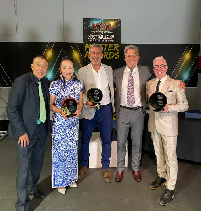 A group of people standing next to each other holding trophies.