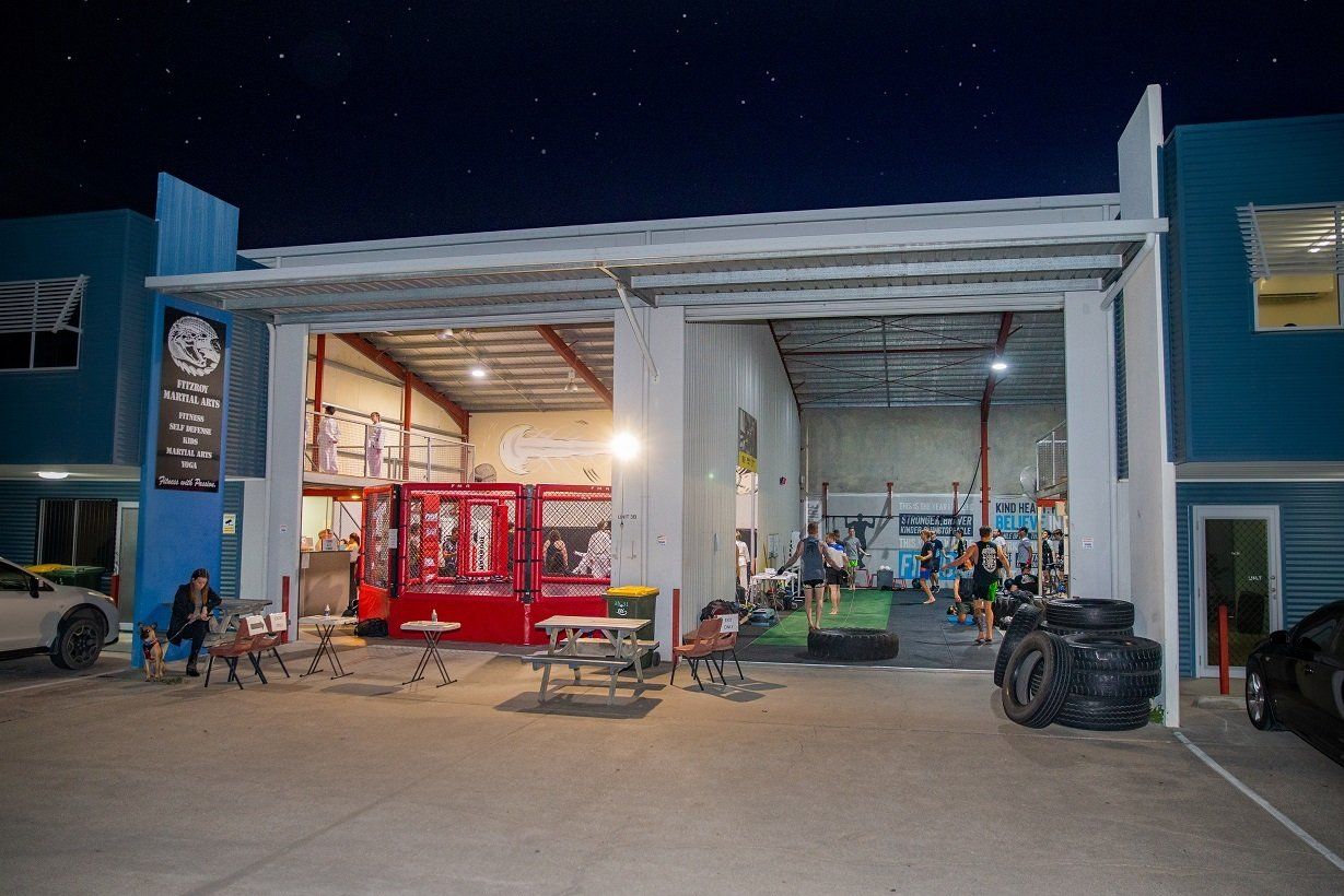 A group of people are standing outside of a building at night.