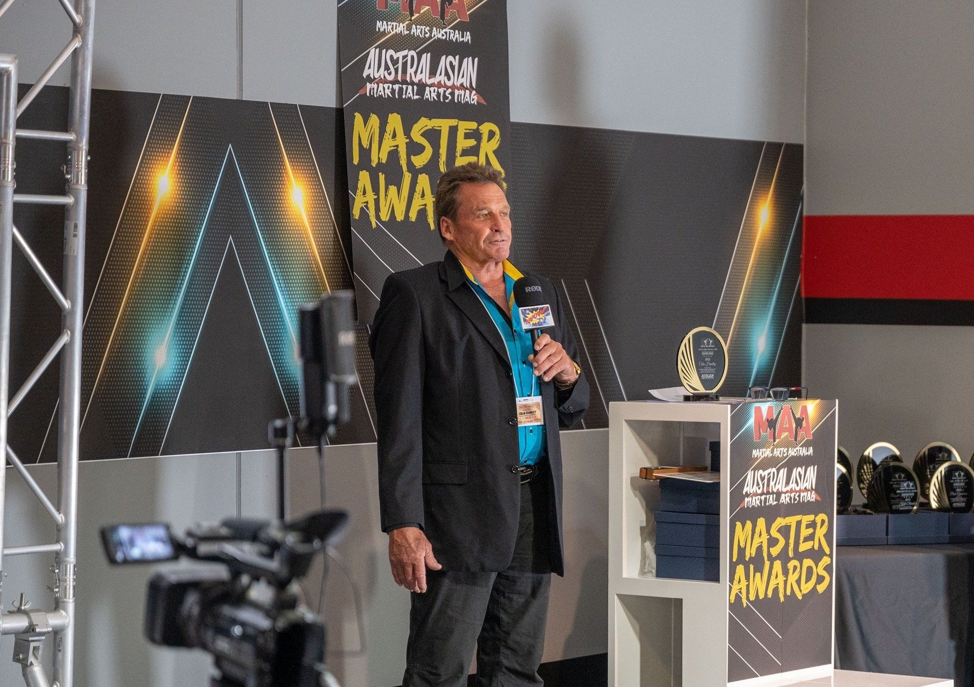 A man is standing in front of a sign that says master awards