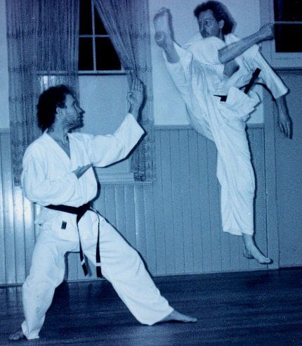 Two men are practicing martial arts in a room