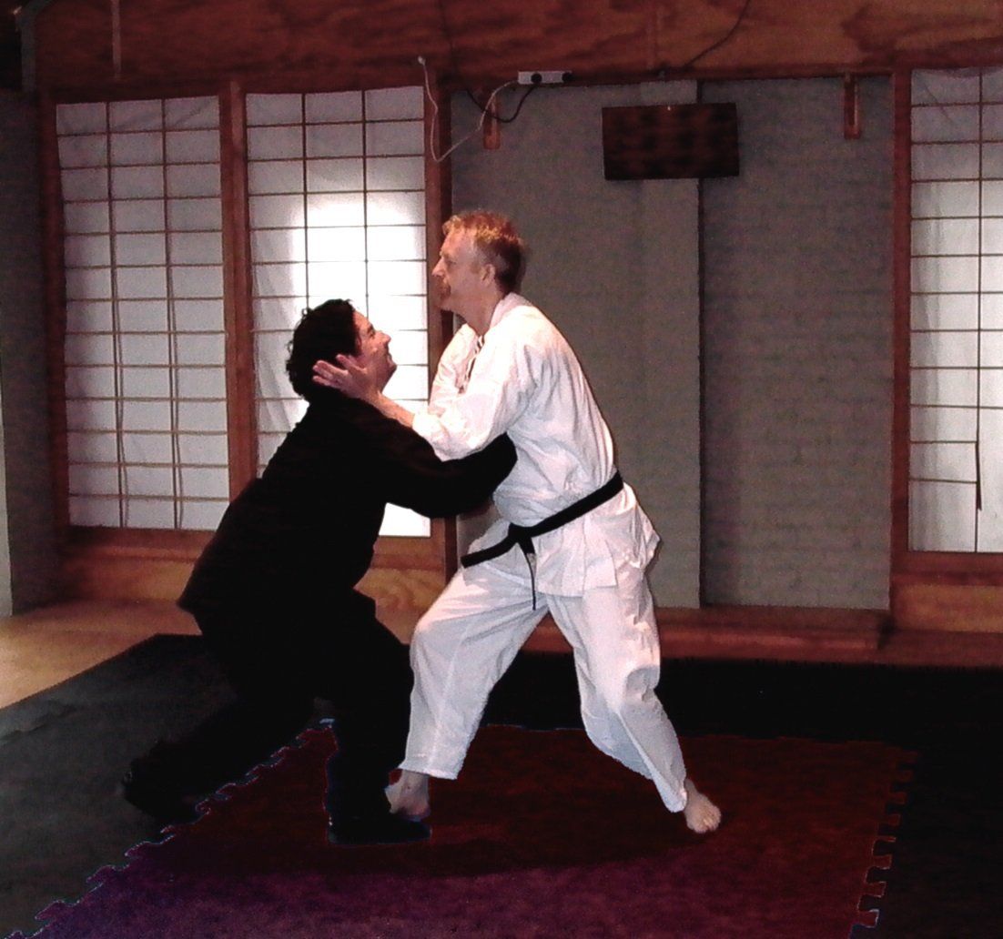 Two men are practicing martial arts in a gym