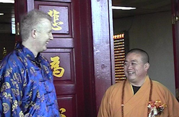 Two men are standing in front of a door with chinese writing on it