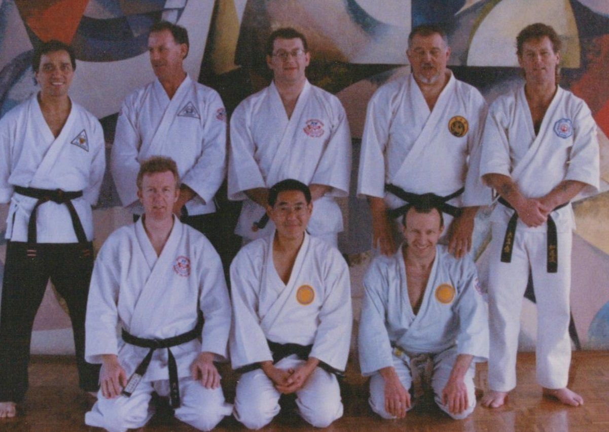 A group of men in karate uniforms pose for a picture