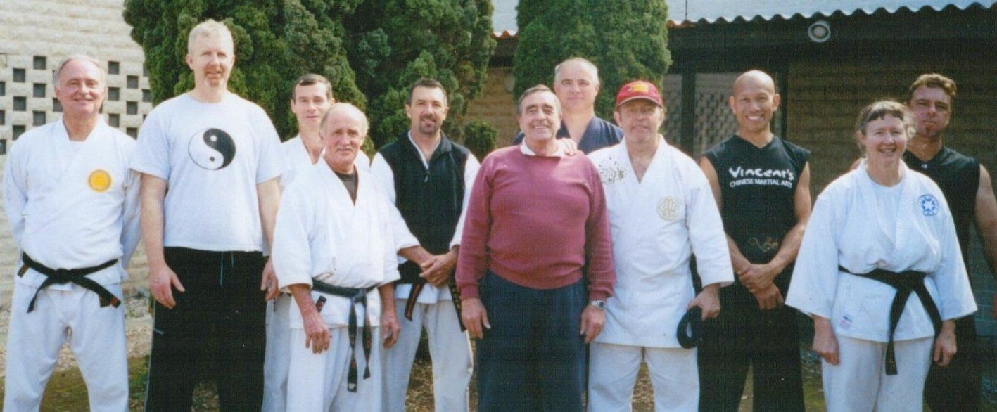 A group of people posing for a picture with one wearing a shirt with a yin yang symbol on it