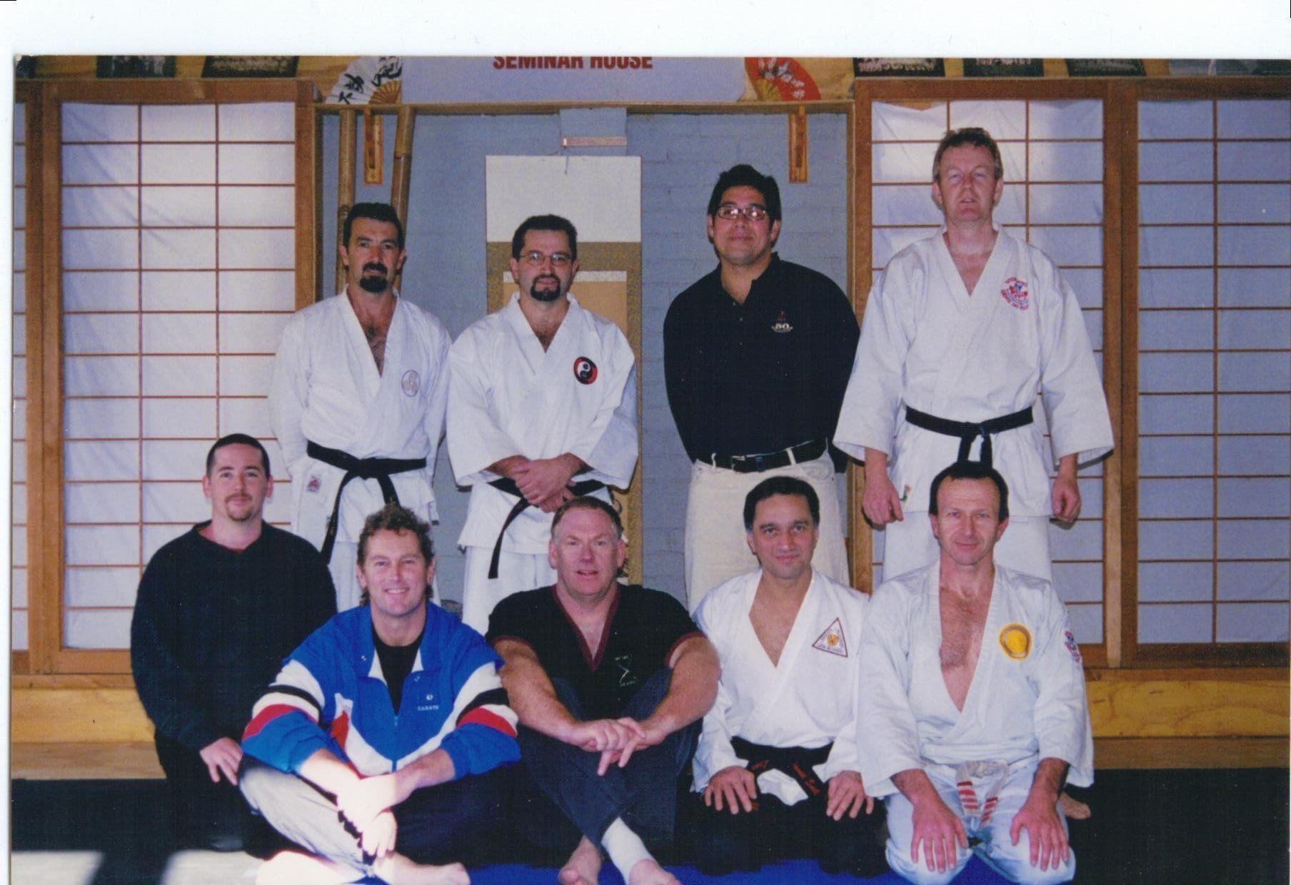A group of men in karate uniforms pose for a picture