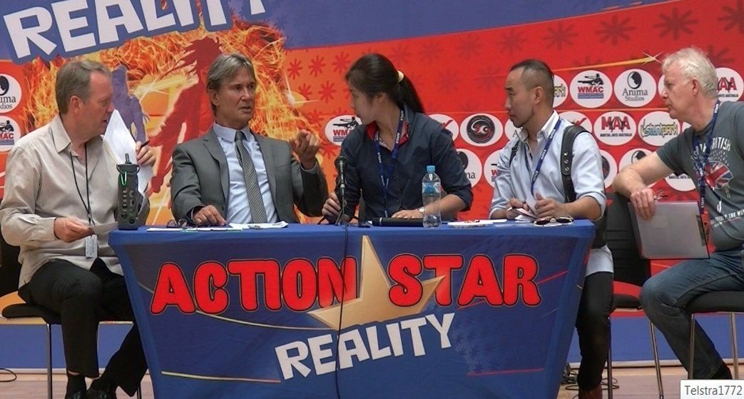 A group of people sitting around a table with a sign that says action star reality