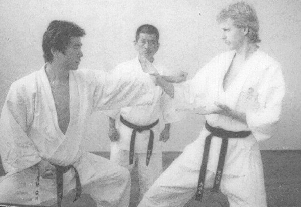 A black and white photo of three men in karate uniforms