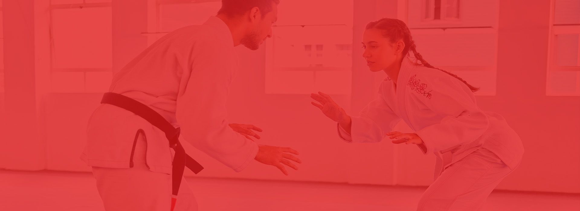 A man and a woman are practicing martial arts in a gym.