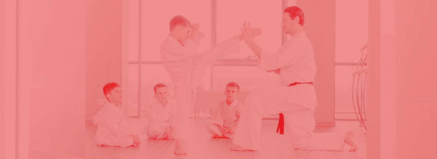 A group of young men are practicing karate in a gym.