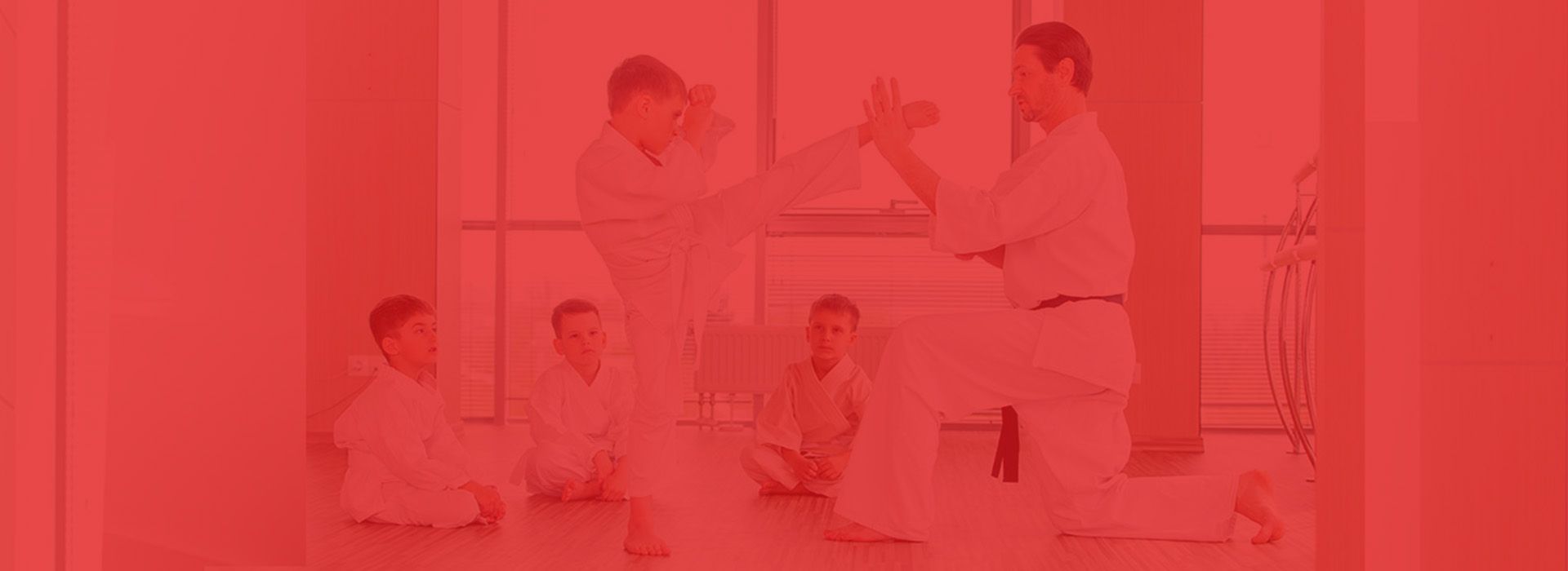 A group of young men are practicing karate in a gym.