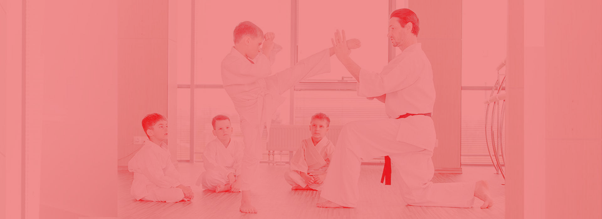 A group of young men are practicing karate in a gym.
