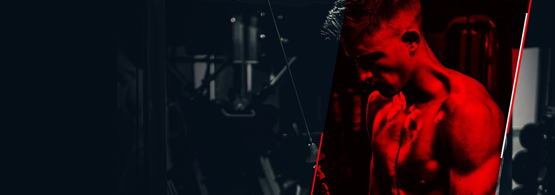 A man in a red shirt is standing in a dark room.