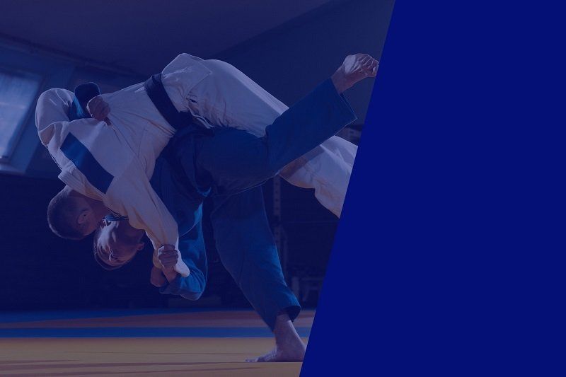 Two men are fighting judo on a blue background.