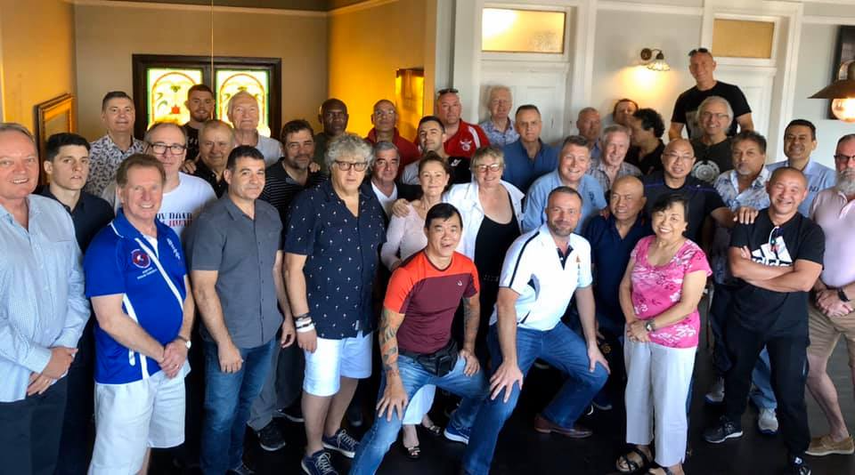 A large group of people are posing for a picture in a room.