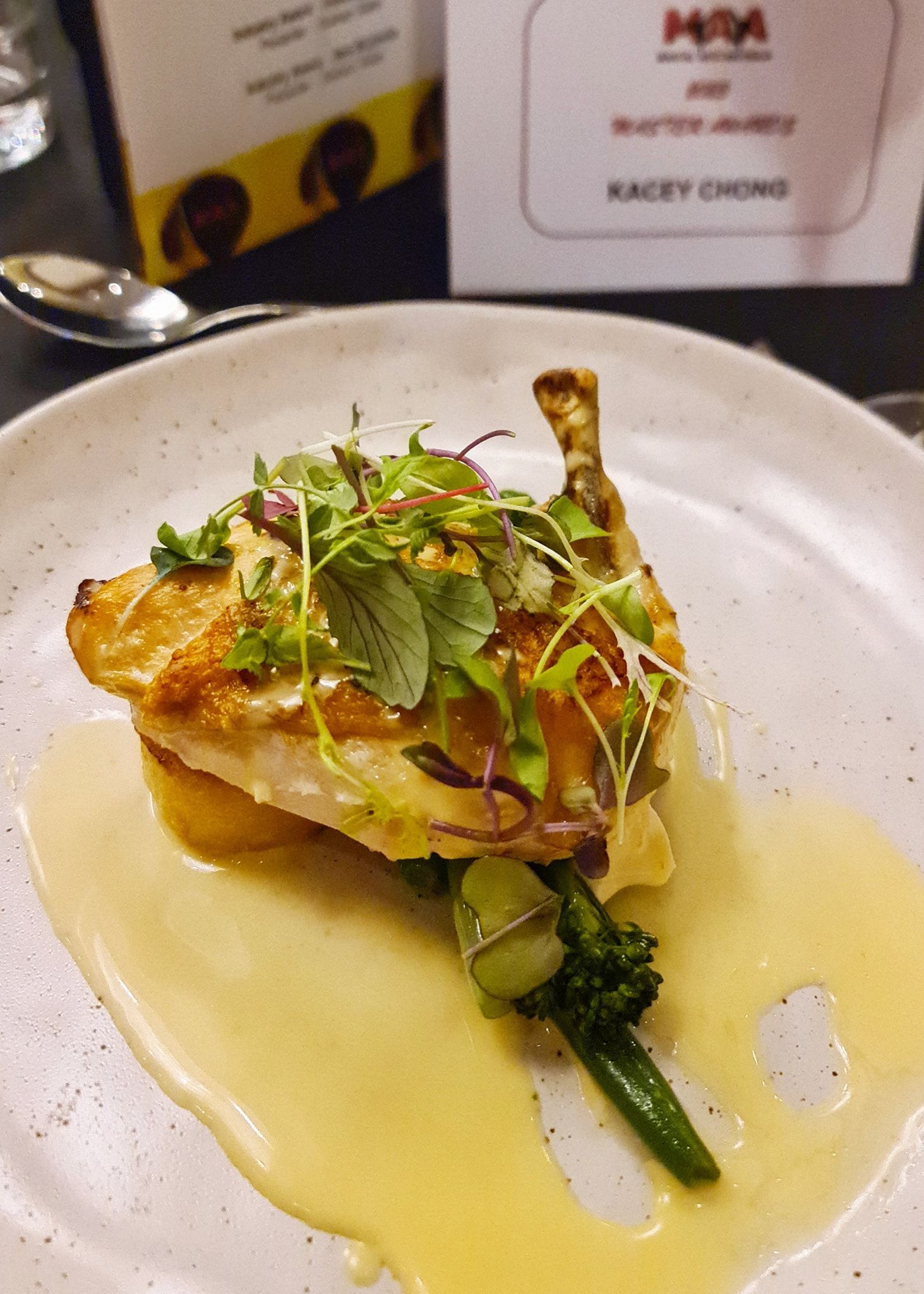 A close up of a plate of food with a spoon on a table.