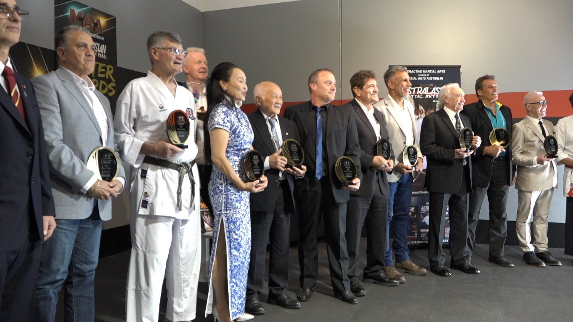 A group of people standing next to each other holding trophies