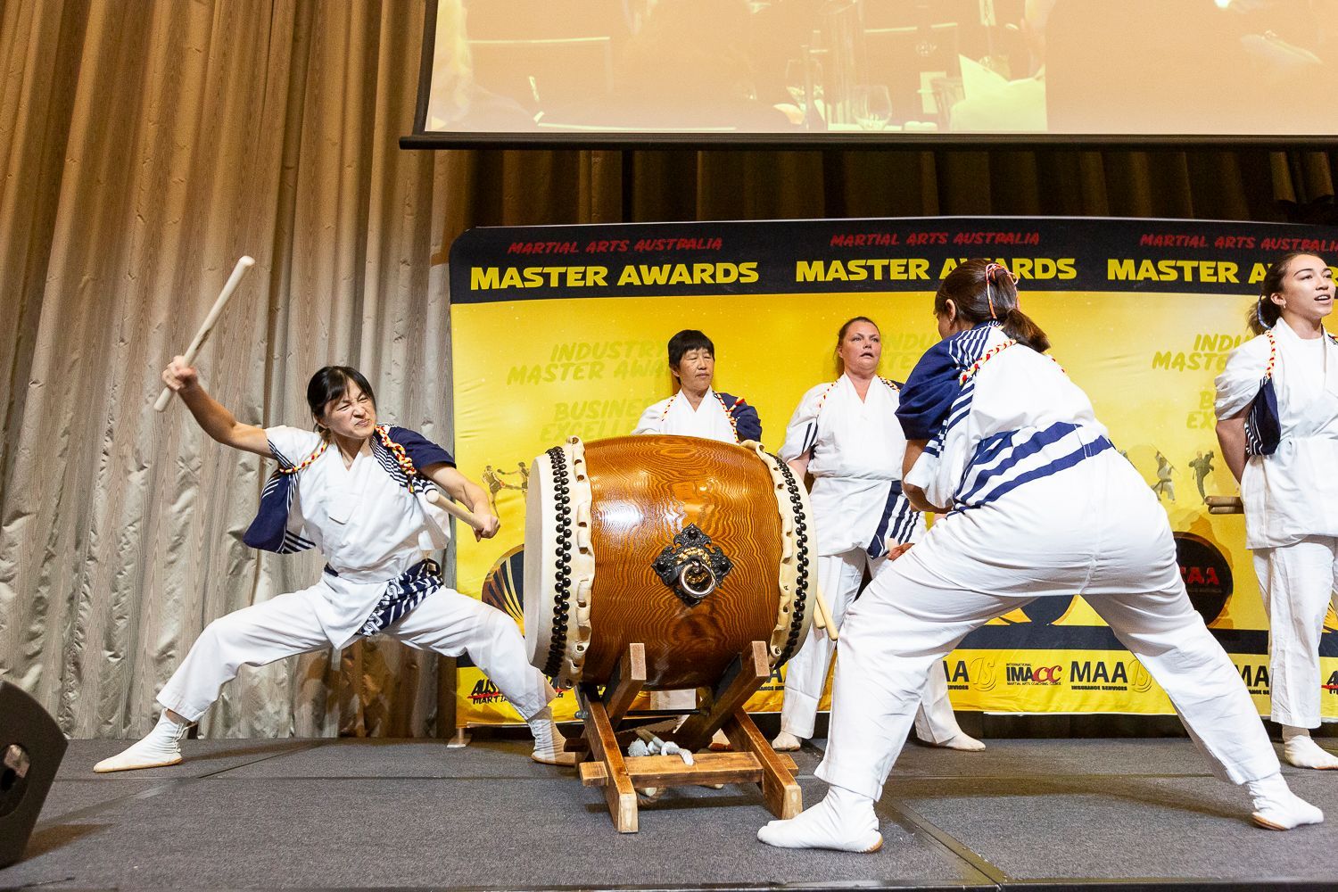 A group of people are playing drums on a stage.