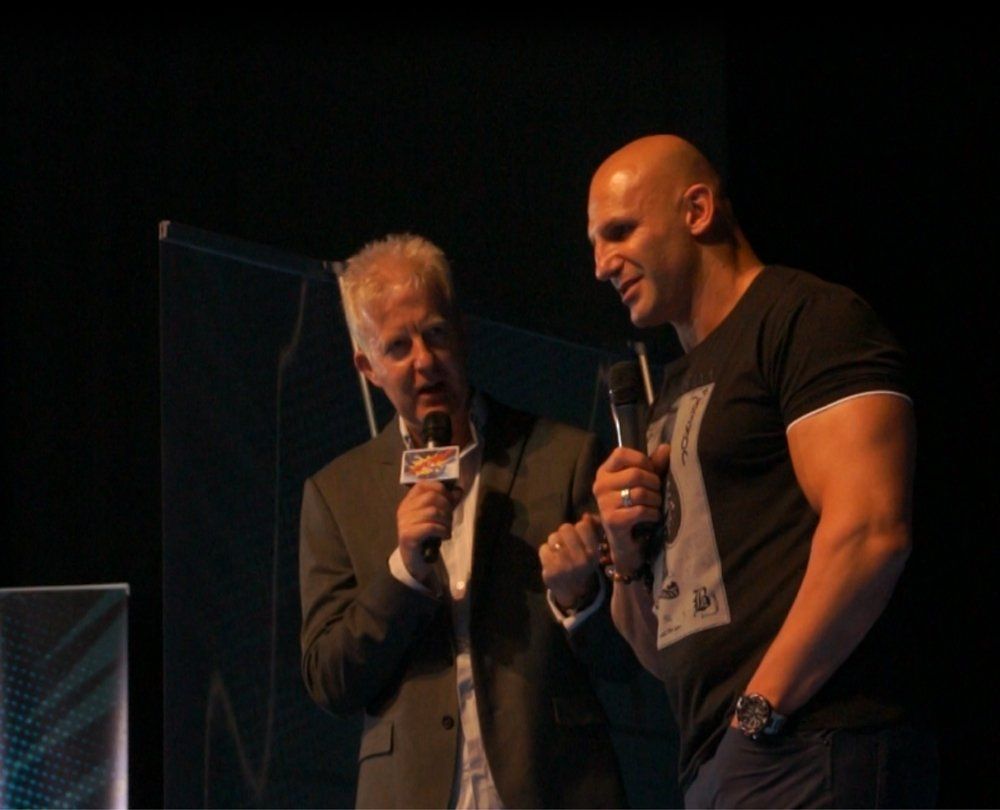 Two men are standing next to each other with microphones in their hands