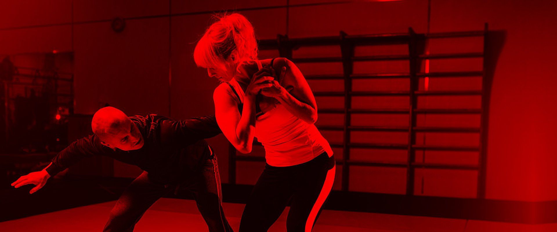 A man and a woman are dancing in a red room.