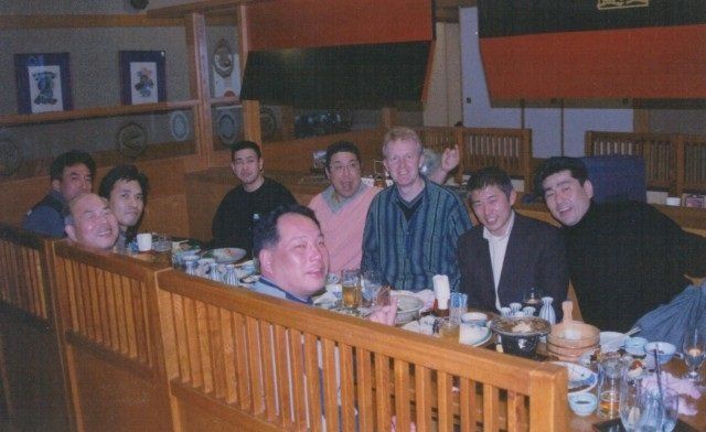 A group of men are sitting at a long table in a restaurant