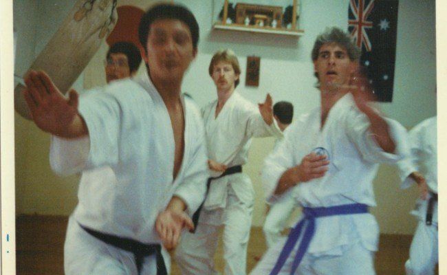 A group of men are practicing martial arts in a gym