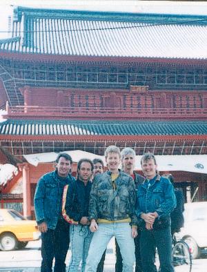 A group of men are posing for a picture in front of a building