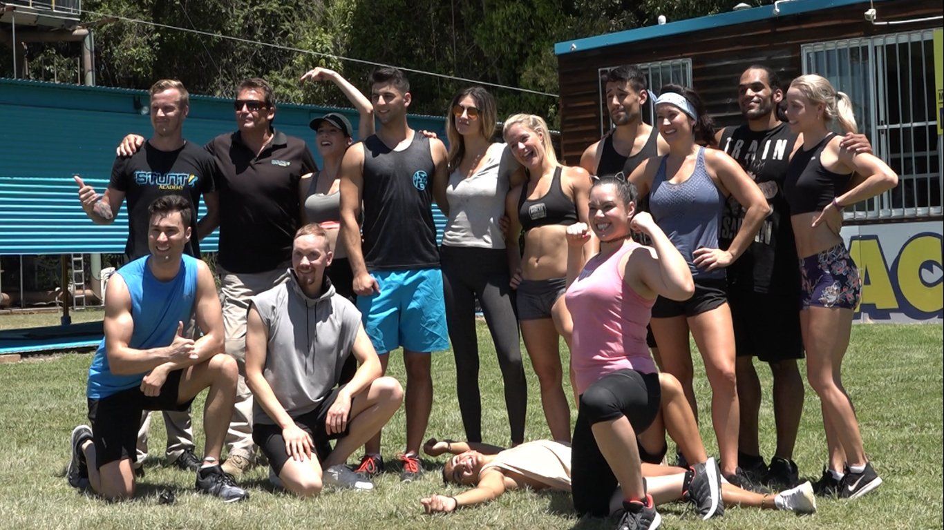 A group of people are posing for a picture in front of a building.