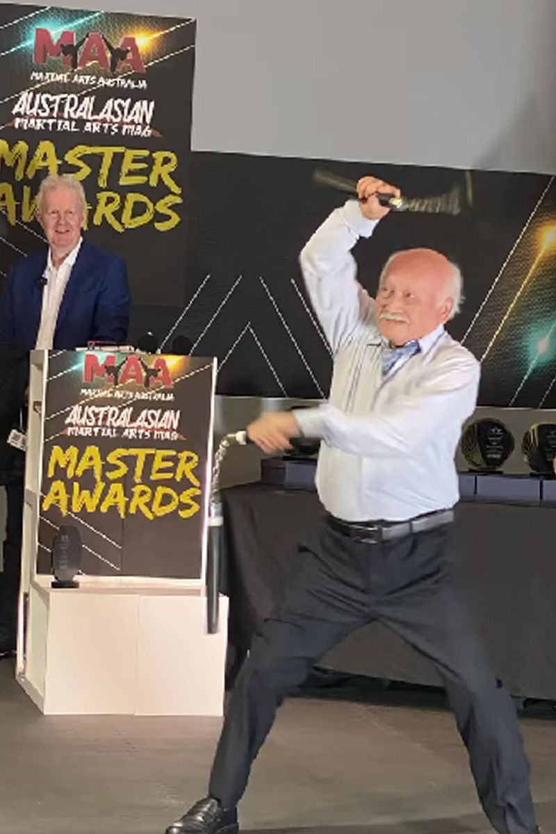 A man is standing in front of a sign that says master awards