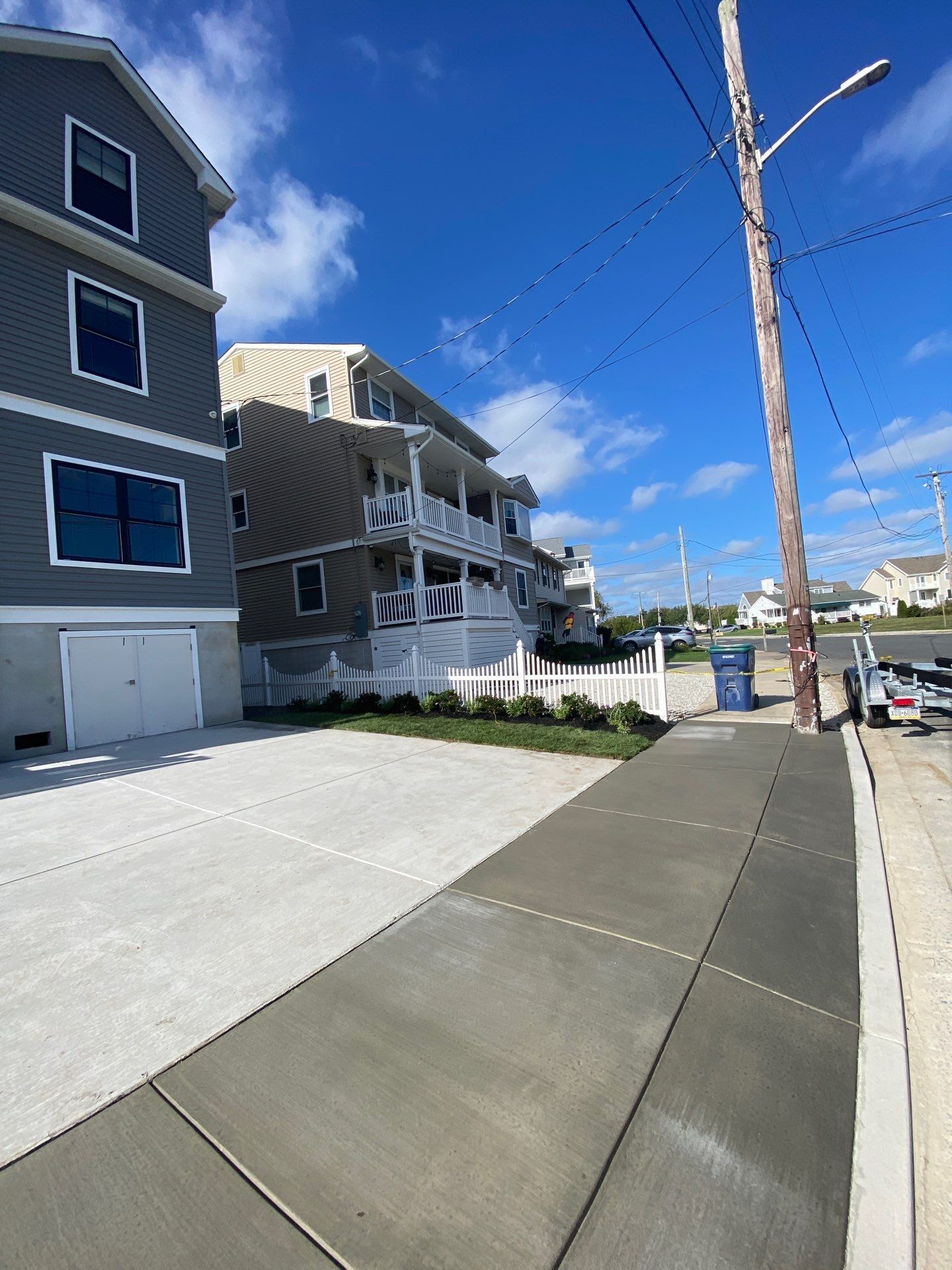 A concrete sidewalk leading to a house on a sunny day
