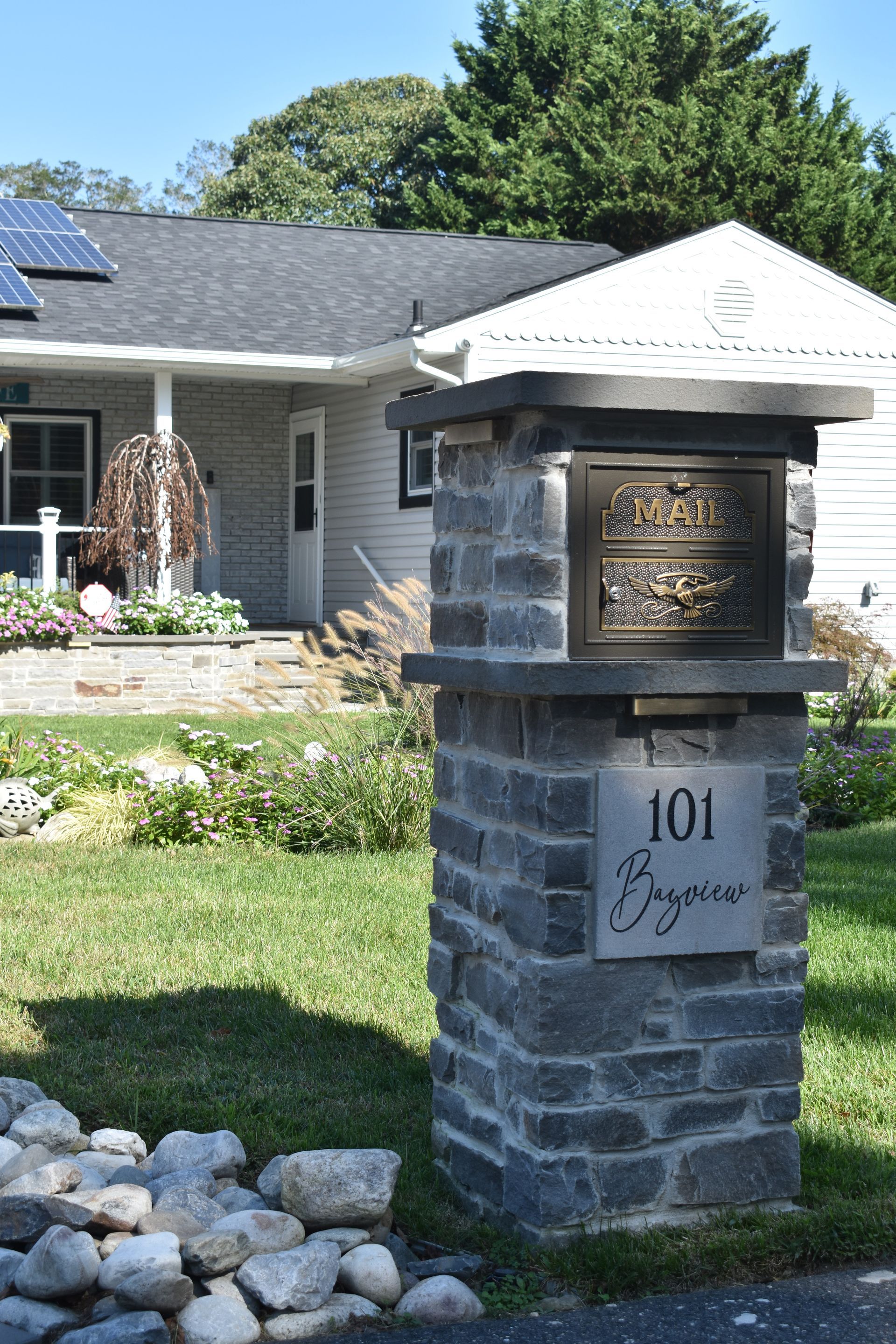 A mailbox in front of a house with the number 101 on it