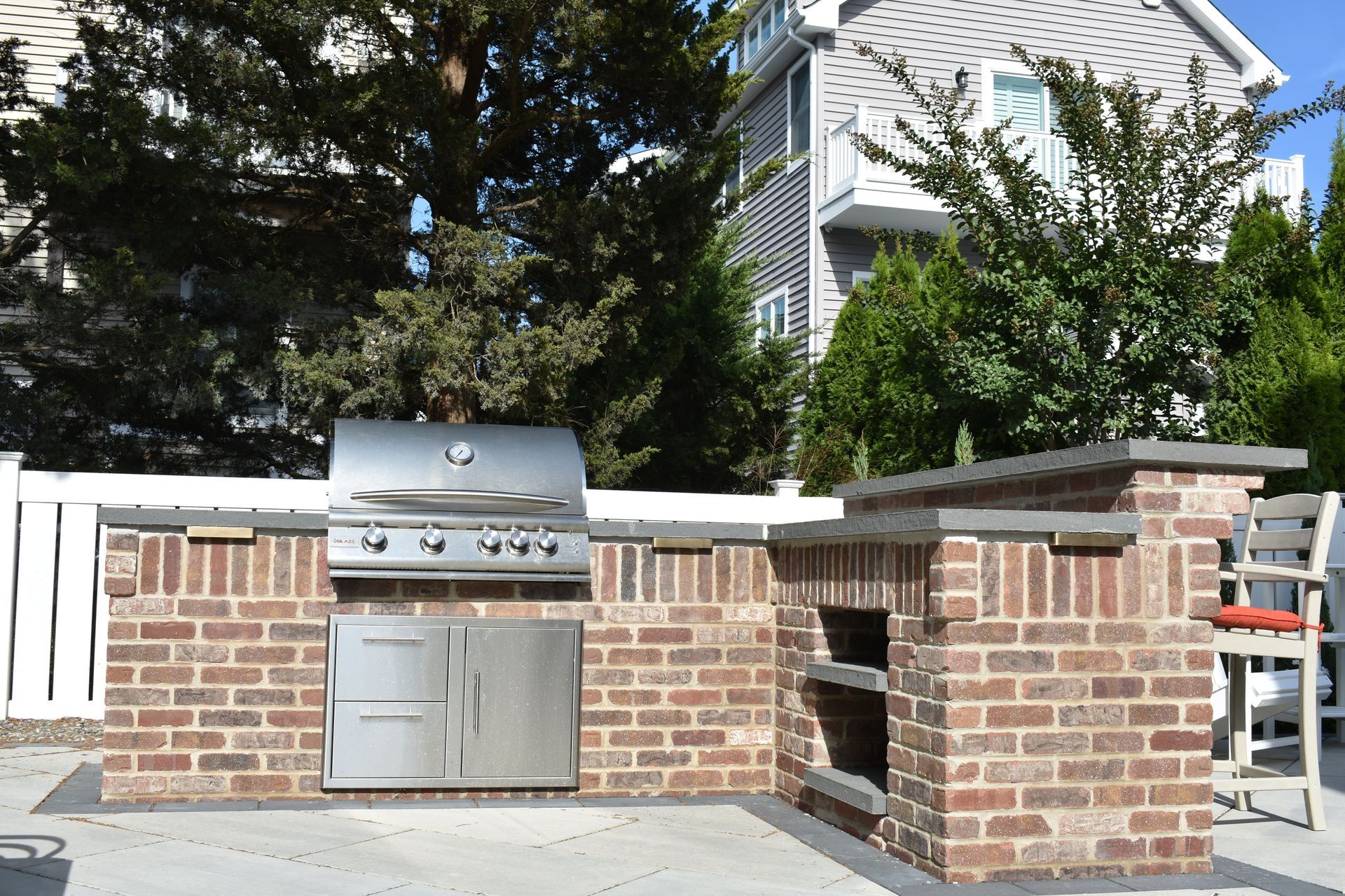 A brick outdoor kitchen with a stainless steel grill