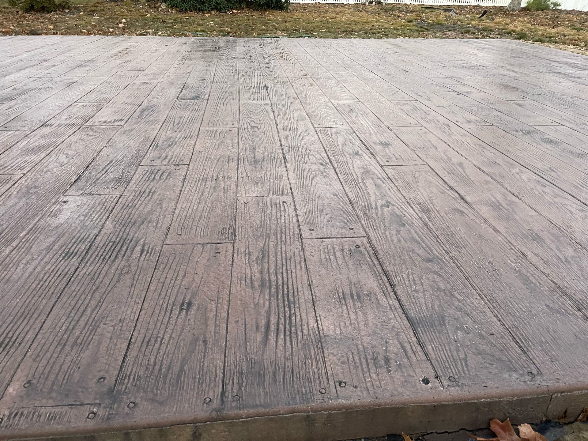 A concrete floor with a wooden pattern on it.