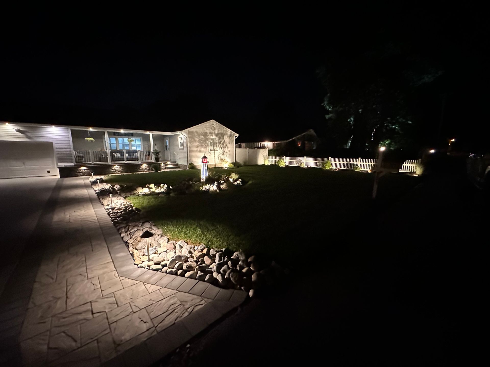 A house is lit up at night with a walkway leading to it.