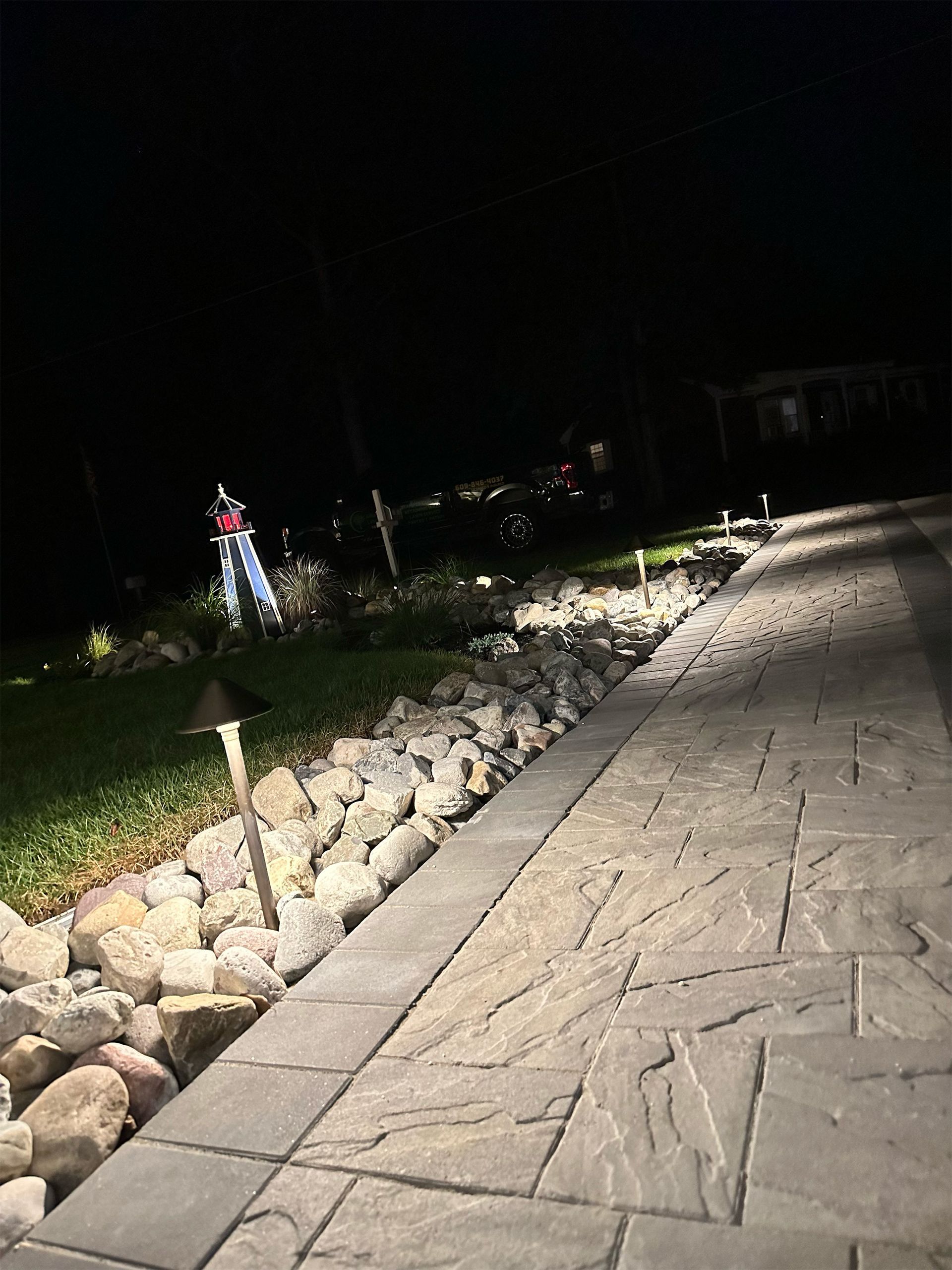A stone walkway is lit up at night.