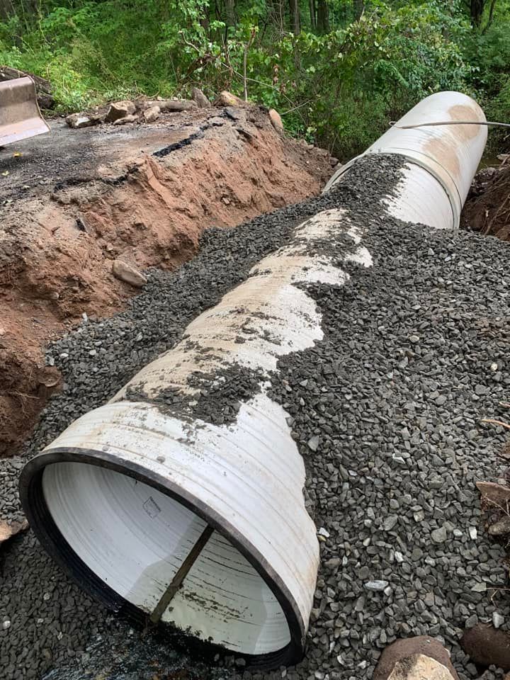 A couple of pipes laying on top of a pile of gravel.