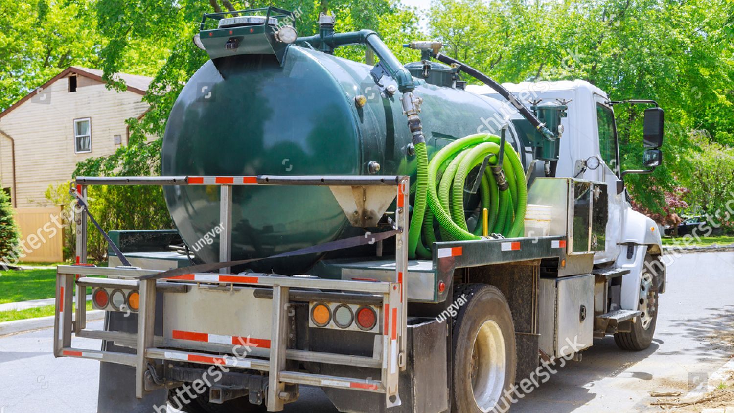 A vacuum truck is parked on the side of the road.