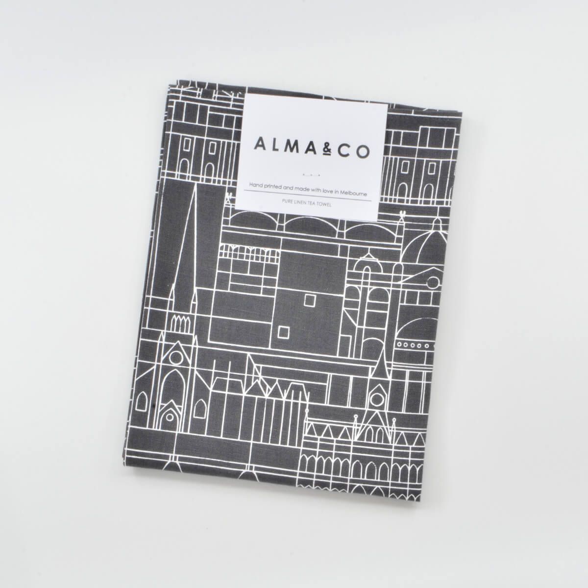 a linen tea towel featuring a white-on-black illustration of buildings in the city of Melbourne