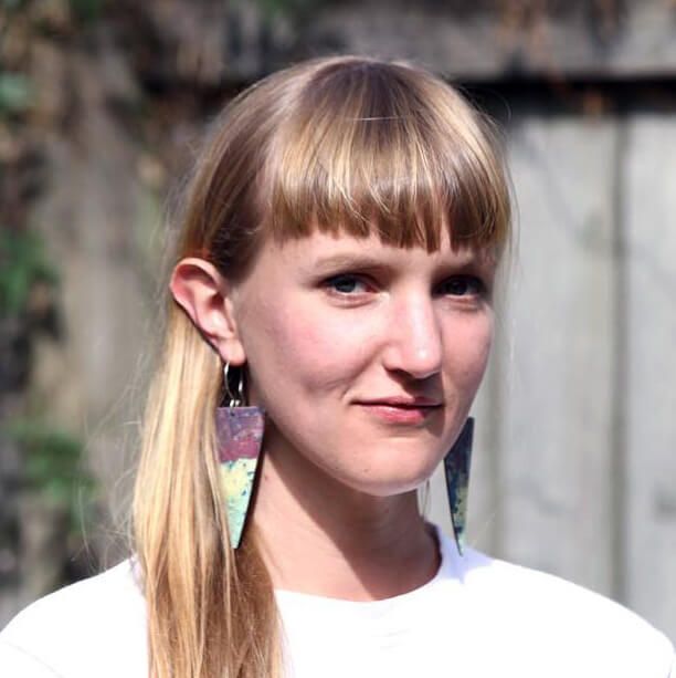 Grace Huie Robbins wearing a white t-shirt and long triangular earrings