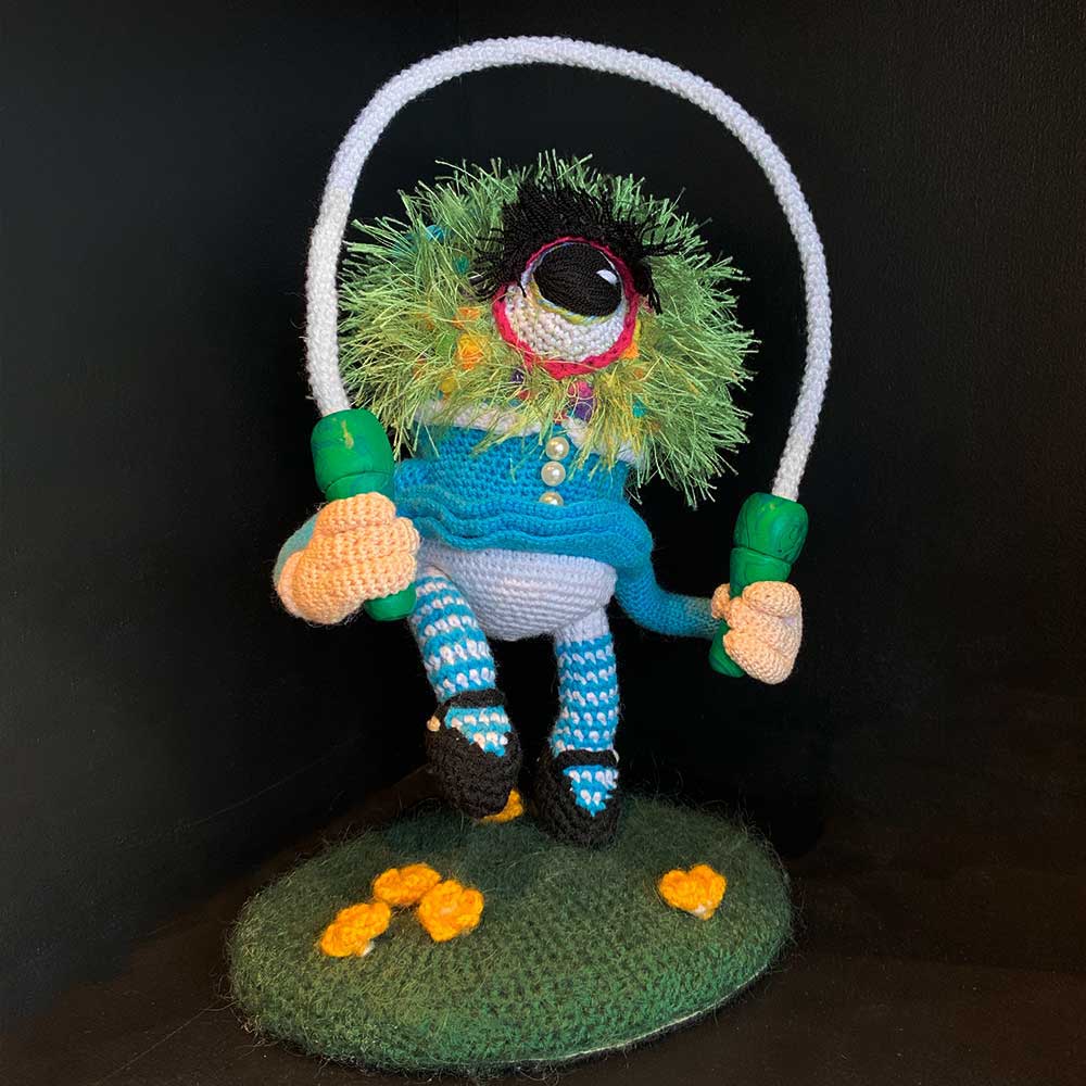 soft sculpture of a one-eyed creature with skipping rope