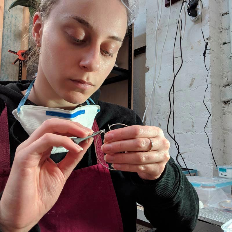 Renee Serraglio has an expression of concentration on her face as she works on a piece of fine-wire jewellery