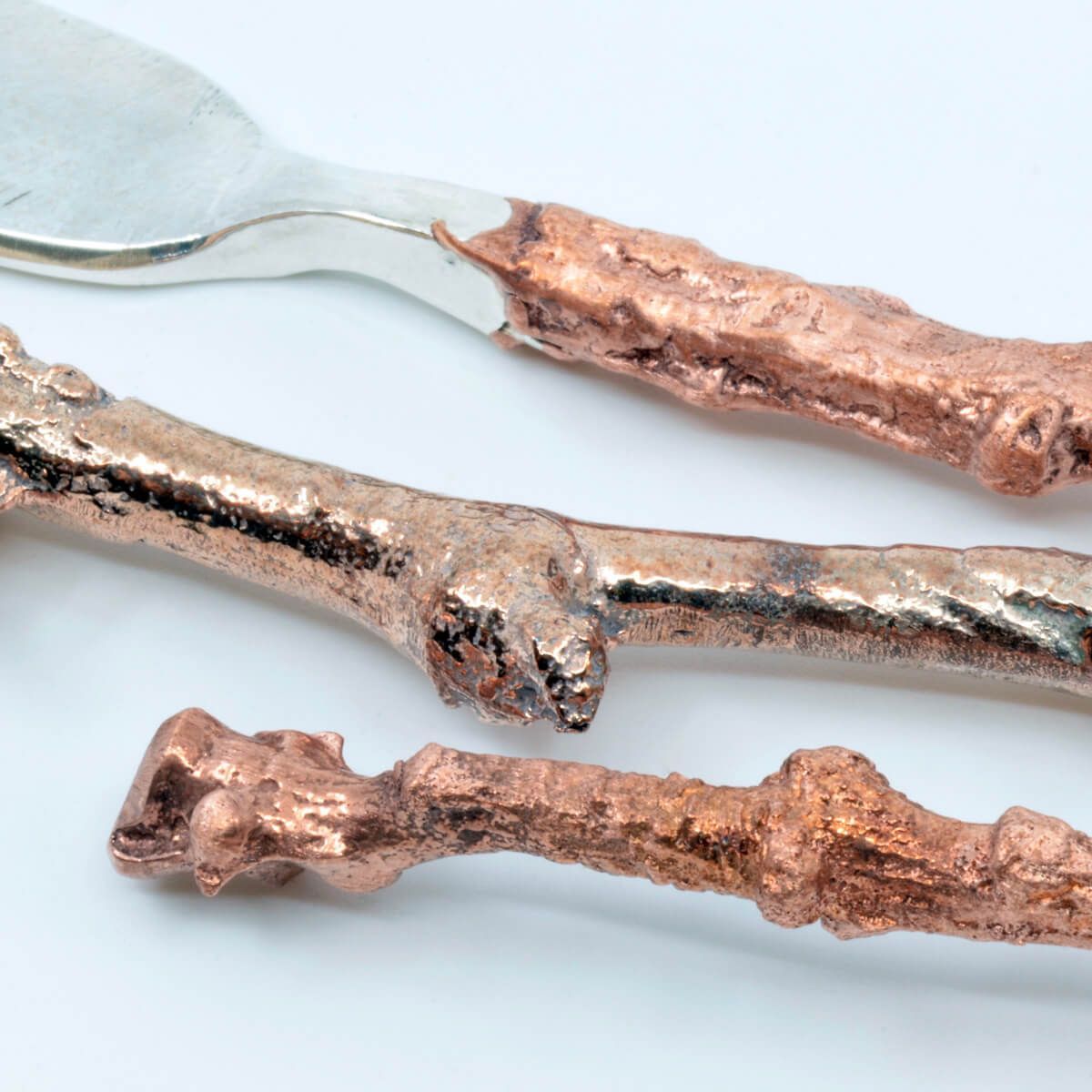 the handles of a small metal fork, knife, and spoon