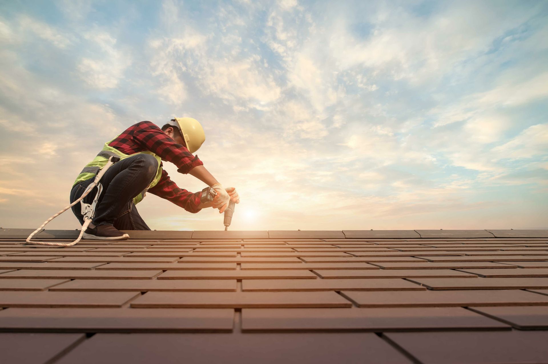 Man working on roof at sunset, showcasing skills as a commercial roofing contractor. Man working on roof at sunset, showcasing skills as a commercial roofing contractor.
