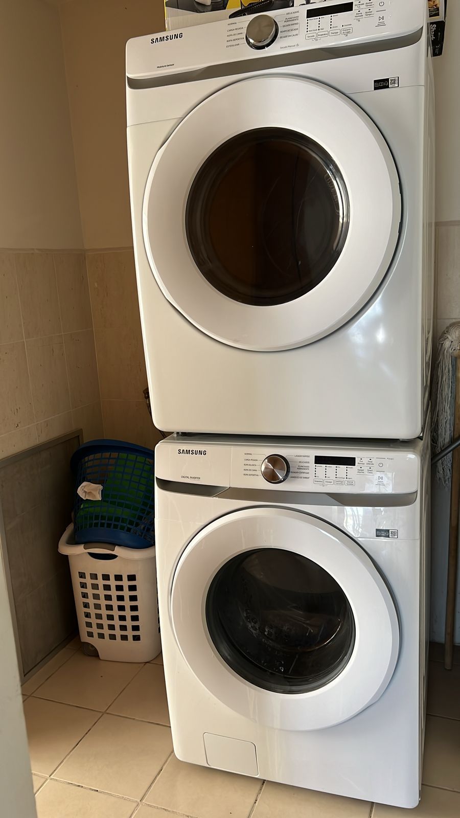 Una lavadora y una secadora están apiladas una encima de otra en un lavadero.