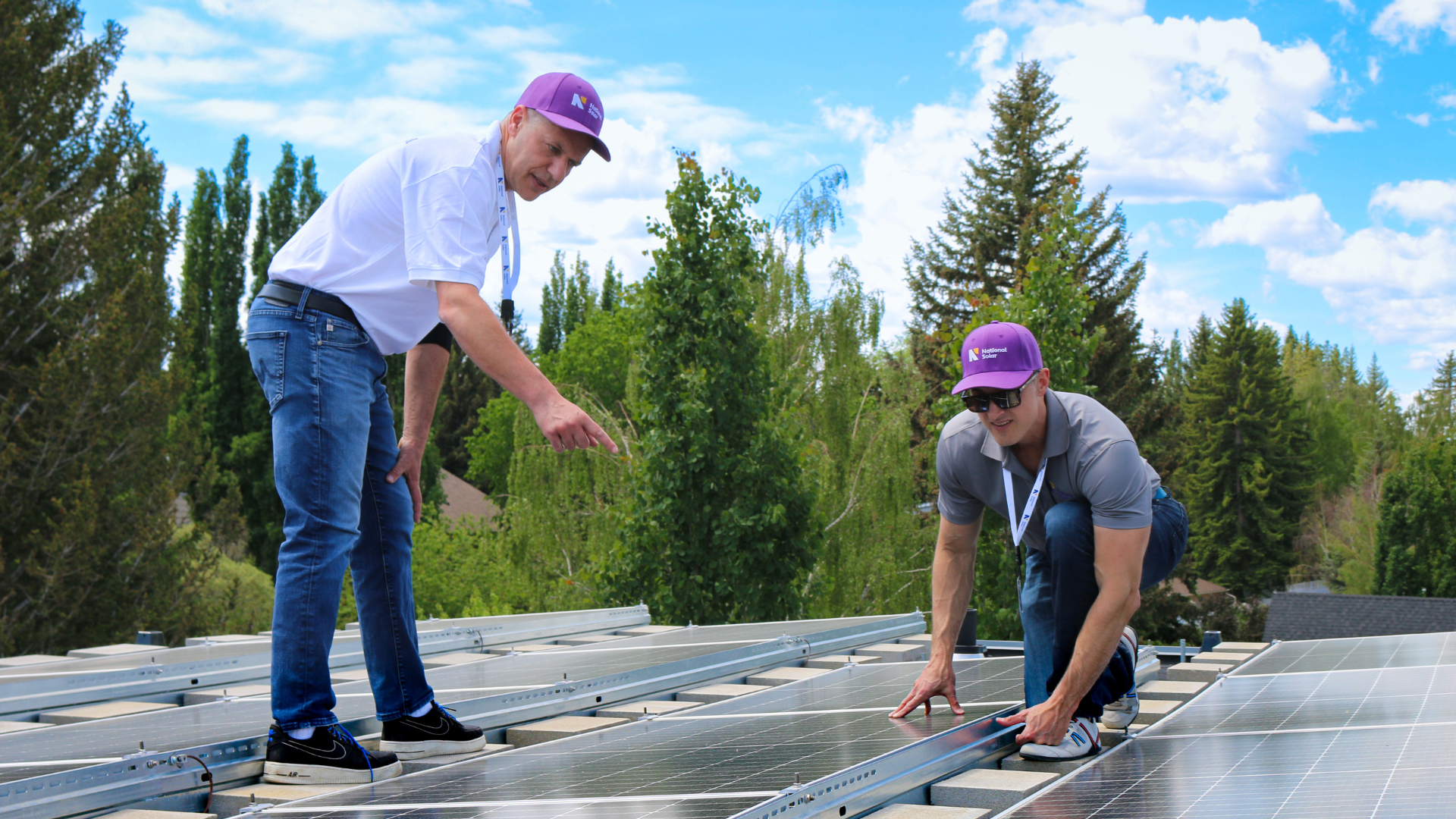 Two men are working on a solar panel on a roof