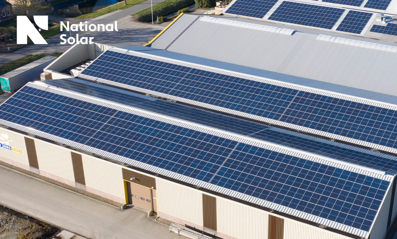 An aerial view of a building with solar panels on the roof