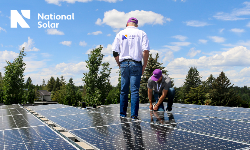 Two men are working on a roof with national solar in the background