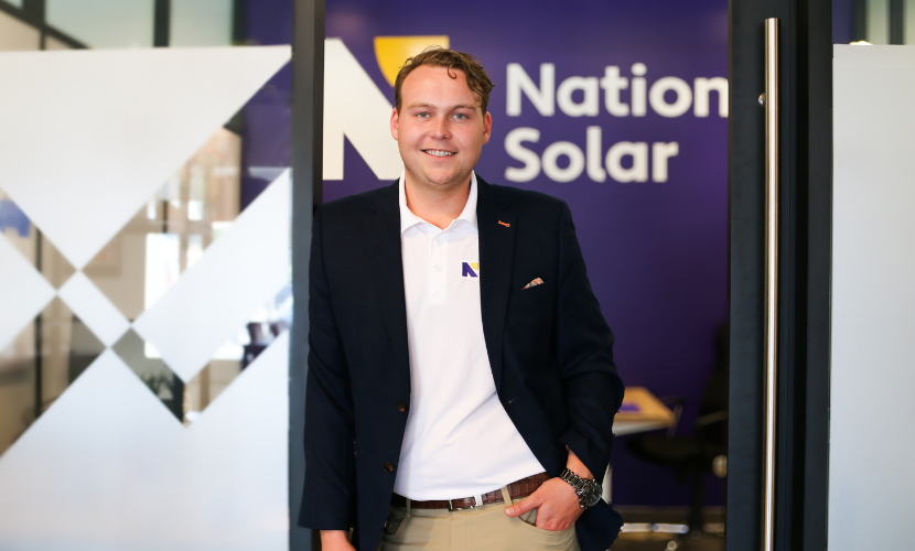 A man standing in front of a nation solar sign