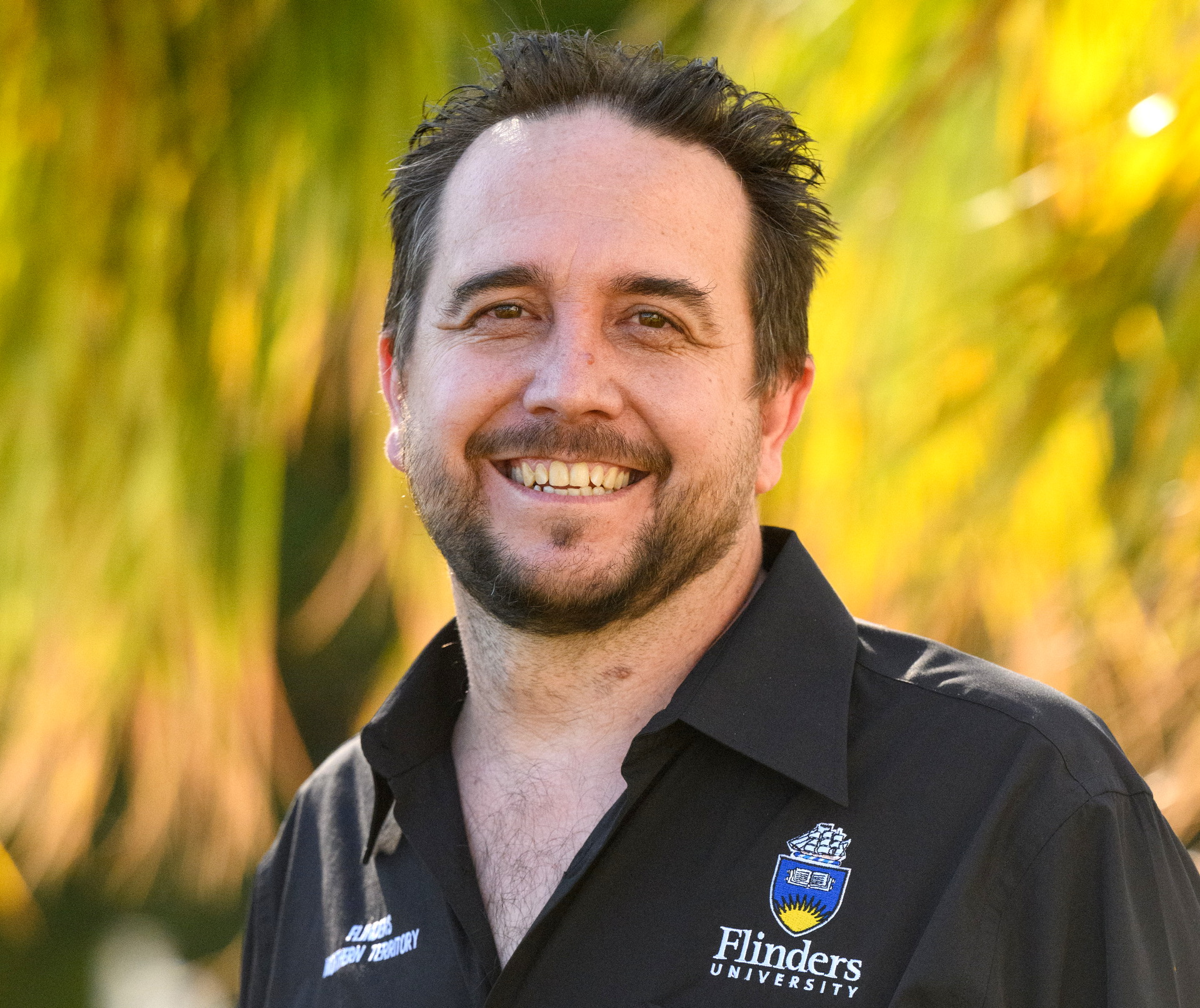 A woman with a braided ponytail is standing in front of a blue sky.
