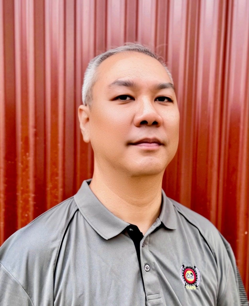 A woman in a black polka dot shirt is smiling with her eyes closed